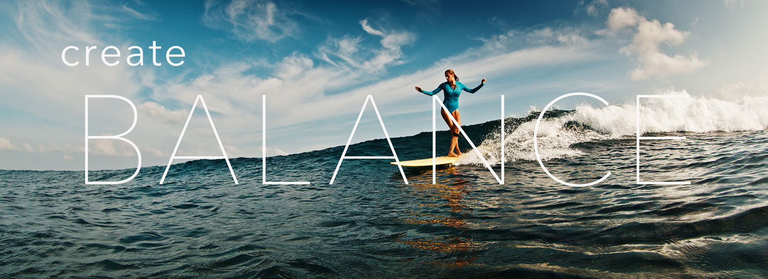 image of a women surfing on a longboard with words "create balance" over the image.